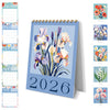 Calendario de escritorio azul para enero de 2026 con ilustraciones florales y cuadrículas mensuales.