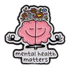 Enamel pin featuring a pink brain with flowers and the text mental health matters