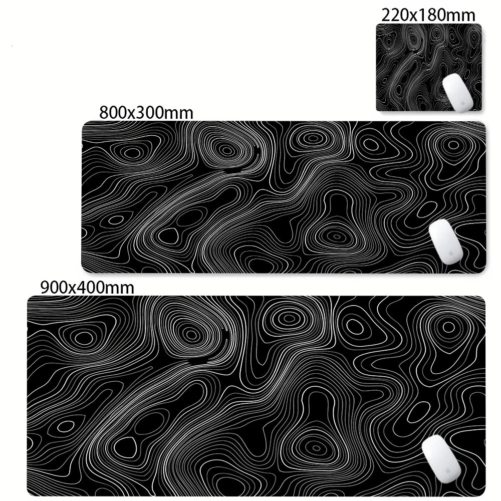 Black abstract desk mat with swirling white lines and a white mousepad visible on the side