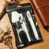 A black pouch contains a set of cute cartoon school stationery including a white eraser and several pens.