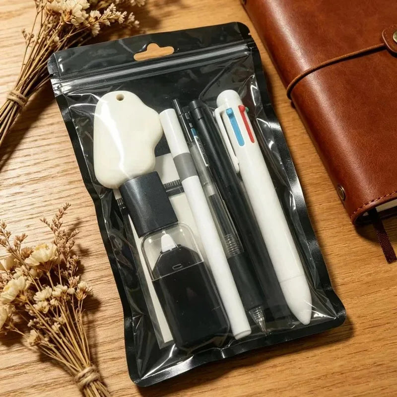 A black pouch contains a set of cute cartoon school stationery including a white eraser and several pens.