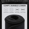A close-up view of a black, thick, rolled desk mat with a precision lock edge and non-slip rubber base.