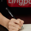 A hand is writing with an all-metal pen on a piece of paper.
