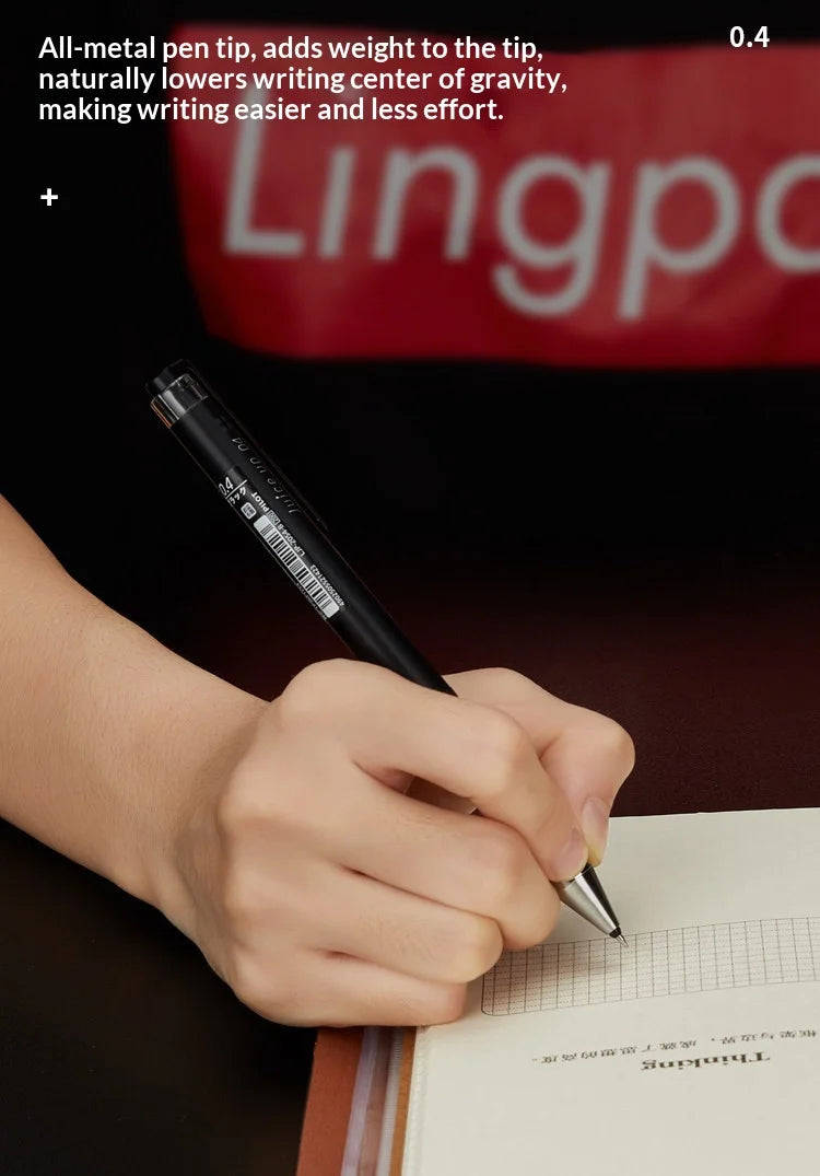 A hand is writing with an all-metal pen on a piece of paper.