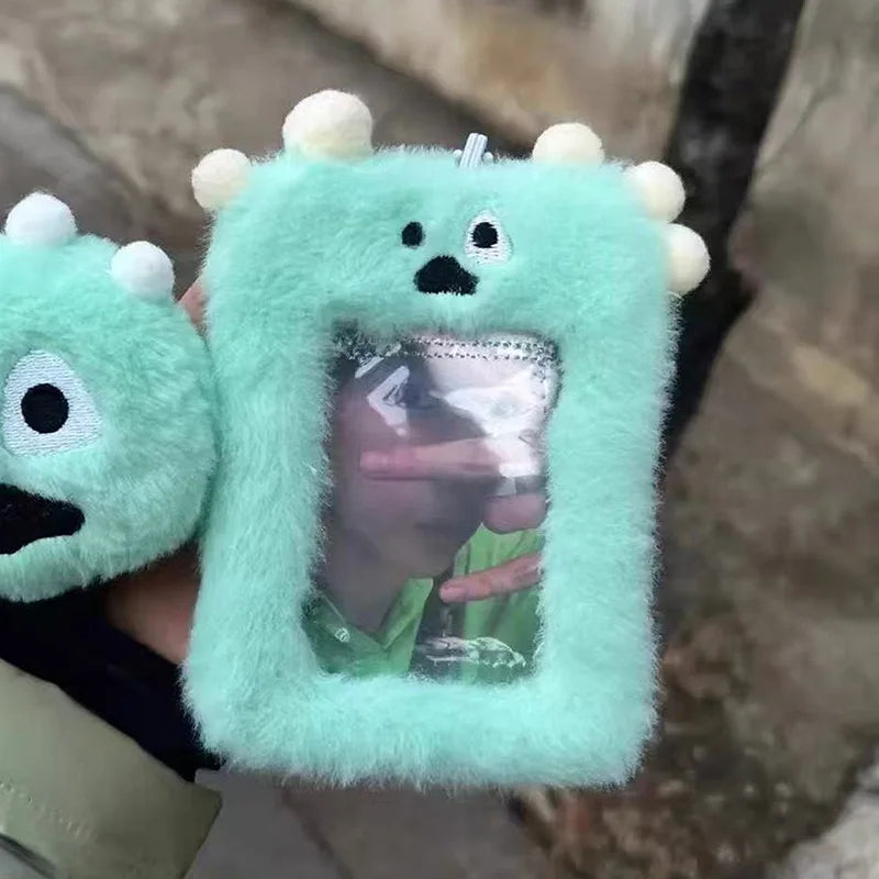 A light mint green plush holder with a clear window displaying a photocard inside.