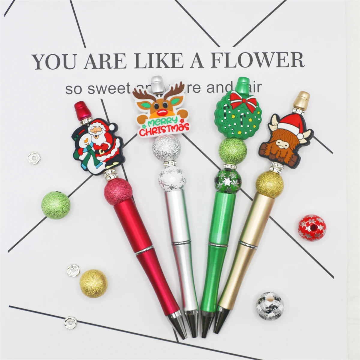 A set of decorative beaded ballpoint pens featuring Christmas and floral themes.