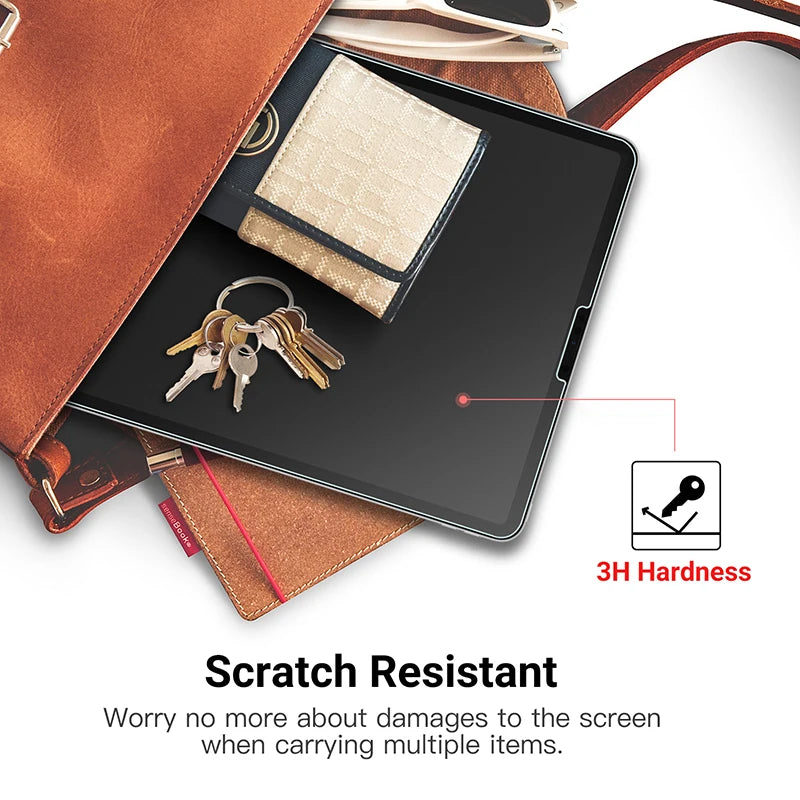 Une tablette sombre montrant un film protecteur et un jeu de clés, démontrant la résistance aux rayures.