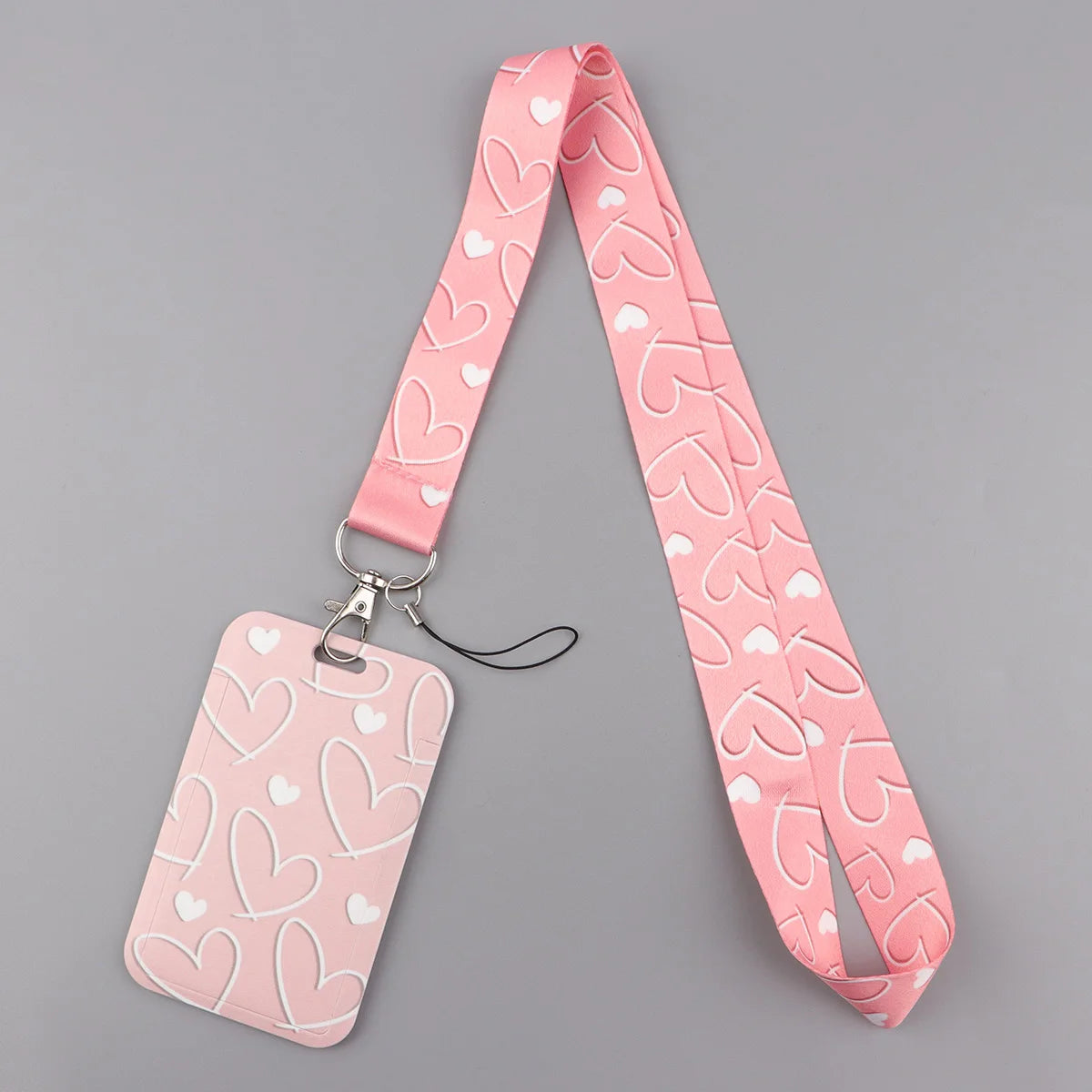 A pink heart-shaped lanyard with a matching tag is displayed against a gray background.