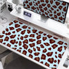 A large desk pad featuring a leopard print design with brown and tan spots on a light blue background.