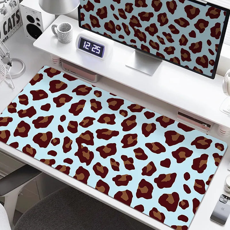 A large desk pad featuring a leopard print design with brown and tan spots on a light blue background.