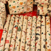 A set of Merry Christmas wrapping paper featuring Santa and tree designs on rolled paper.