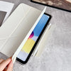 Una mano sostiene un iPad dentro de una funda protectora de cuero sintético premium, mostrando la pantalla y el cuerpo del di