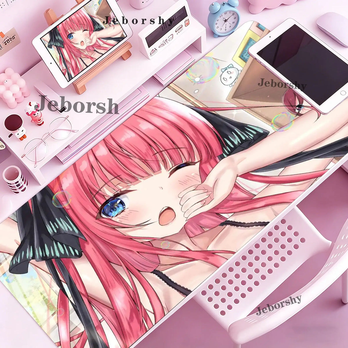 A close-up of a pink-haired anime character illustration on a mouse pad and desk mat with various stationery items.