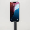 A black magnetic stand holding a smartphone, designed for balancing stability and desk placement.
