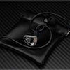 A pair of high-fidelity wired in-ear headphones with a clear housing resting on a black leather case.