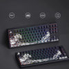 A black mechanical keyboard featuring translucent Ukiyo-e style keycaps with a white and green landscape design.