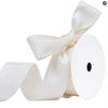 A roll of white matte finish satin ribbon tied into a bow.