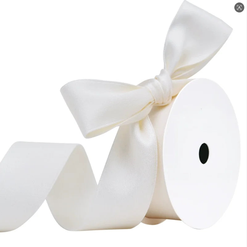 A roll of white matte finish satin ribbon tied into a bow.