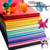 A stack of 100 sheets of premium colored cardstock in various shades, with a small orange cat figurine visible.