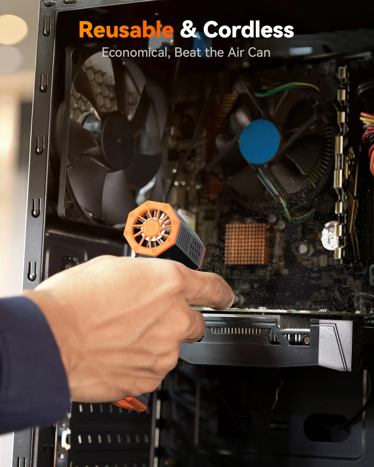 A hand is using an orange electric air duster to clean dust from inside a computer case fan.
