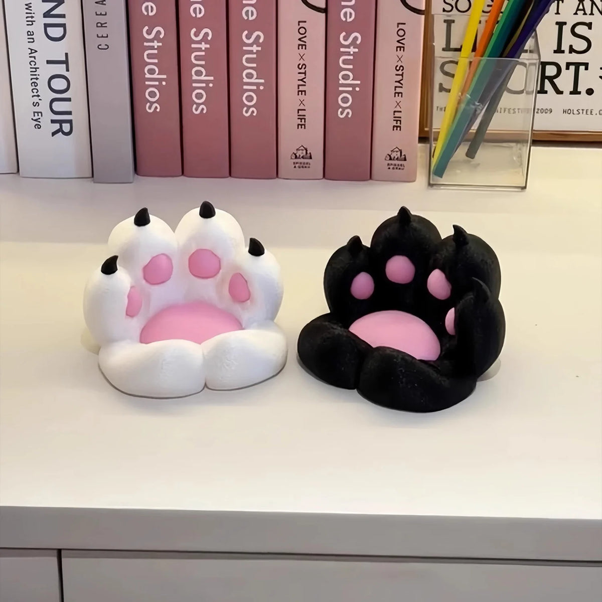 A pair of 3D printed cat paw phone stands, one white and one black, displayed on a white surface.