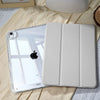 A white universal protective case for an Apple iPad is shown resting on a light fabric surface.