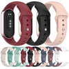 A variety of silicone replacement straps and bands for Mi Band watches in various colors including red black pink and gray.