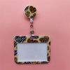 A leopard print card holder clip with a clear plastic ID holder and a round leopard print tag.