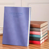 A purple notebook titled ManageTime is displayed next to a stack of brown and colored notebooks.