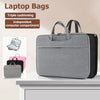 A gray laptop bag with a padded compartment and handles is displayed on a white surface.