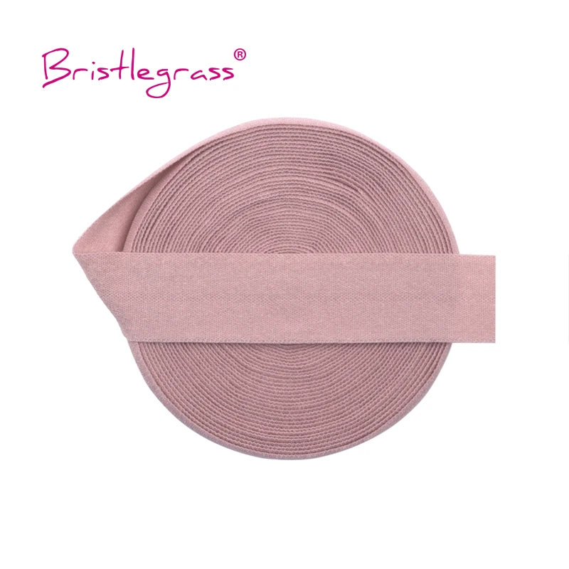 A pink bristlegrass elastic hair tie with a matching pink band shown flat.