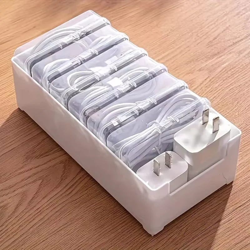 A white plastic storage box holding multiple bundled cables for desk and travel organization.