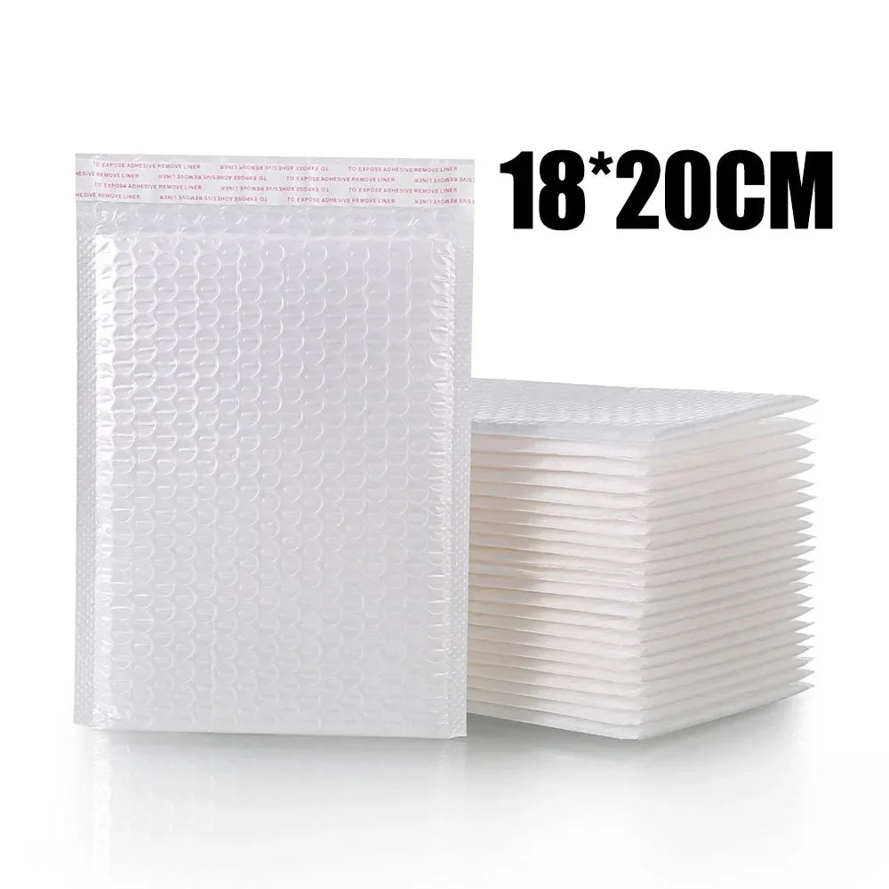 Une pile d'enveloppes blanches rembourrées de 18x20cm, à côté d'une seule enveloppe.