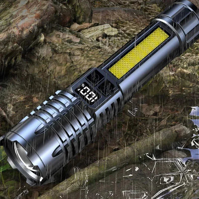 A silver tactical LED flashlight with a yellow light feature is shown outdoors in a rainy, rocky environment.