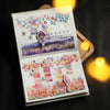 An open notebook page featuring watercolor illustrations and decorative elements for journaling or scrapbooking.