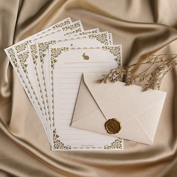 Un set d'enveloppes en papier de lin brun rétro avec des motifs floraux décoratifs et un petit sceau doré sur un tissu de soi