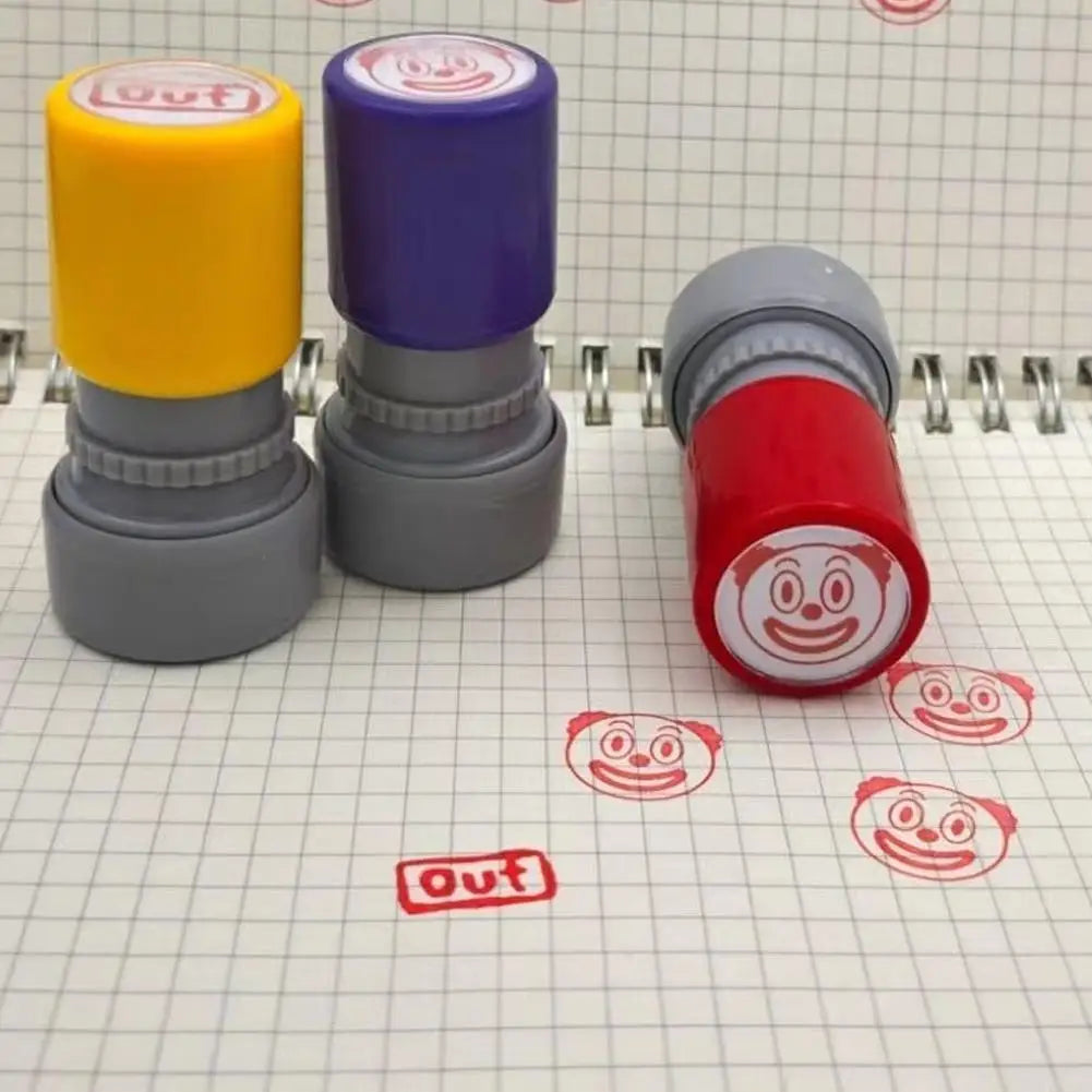 Three self-inking rubber stamps in yellow, purple, and red are shown on a lined paper background.