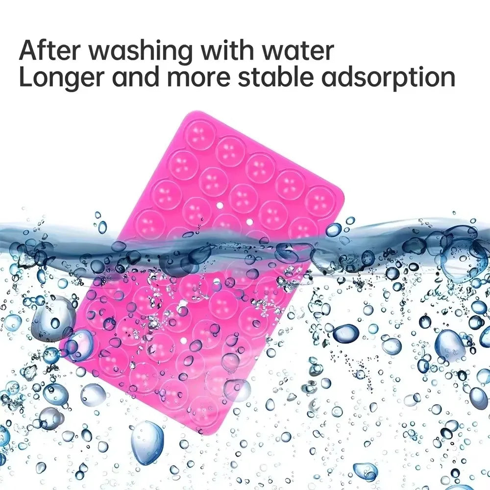 Pink silicone phone mount grip being washed with water and surrounded by bubbles