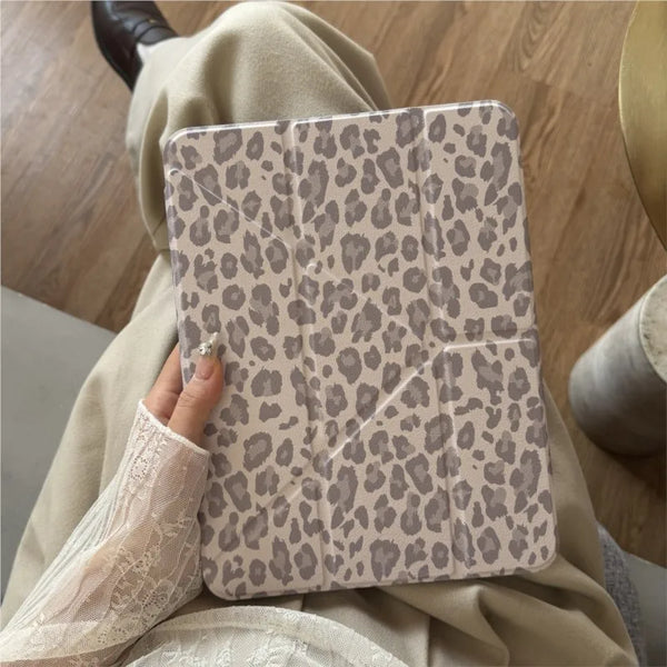 A beige leather case with a leopard print pattern is shown being held by a person.