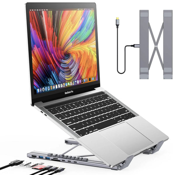 A MacBook Pro laptop is shown alongside a USB-C docking station and an adjustable laptop stand.