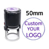 A black self-inking stamp with a clear base and a purple circle indicating 50mm size.