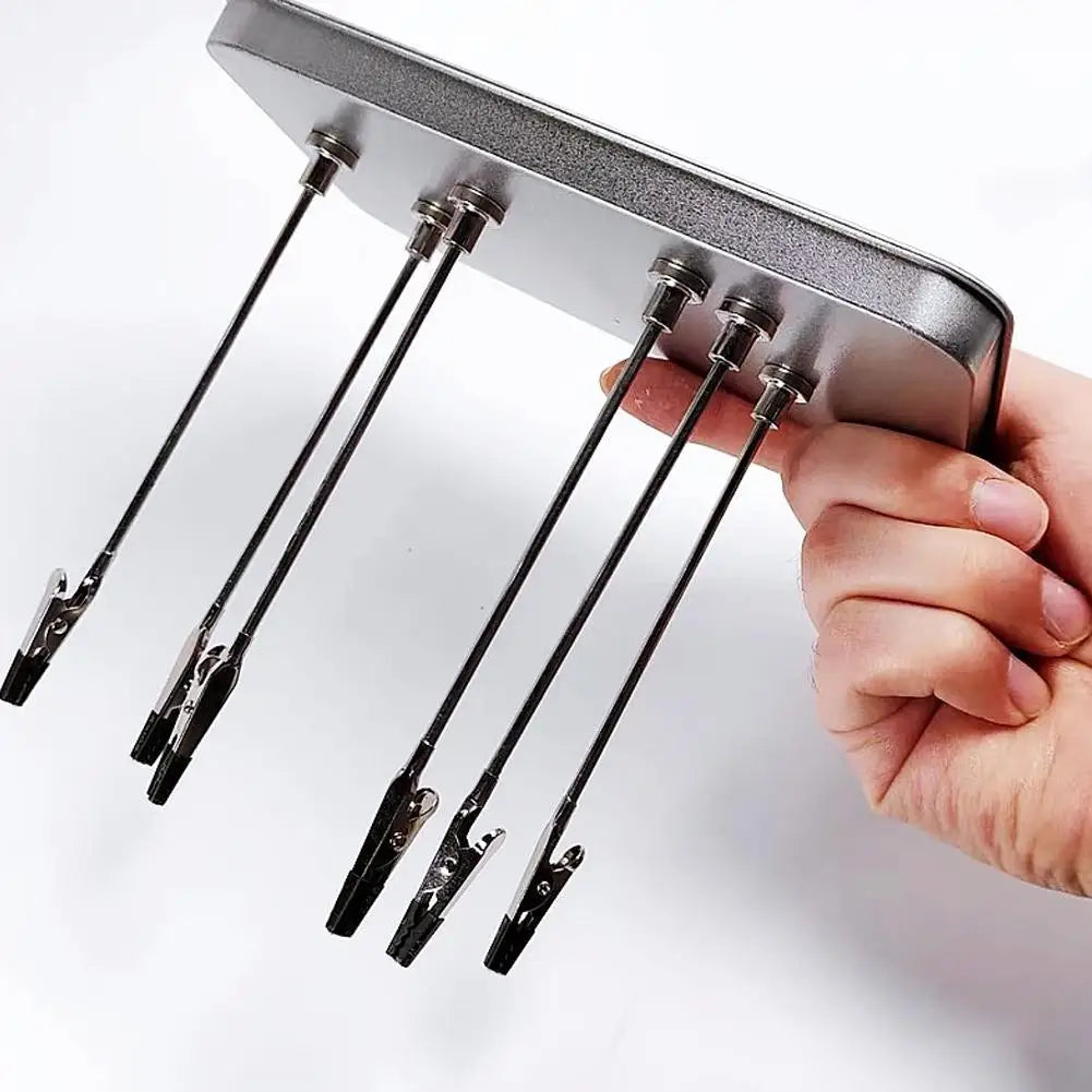A hand holds a magnetic painting stand with multiple metal rods for art and craft projects.