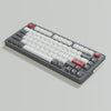 A gray mechanical keyboard featuring retro NES style PBT keycaps with red modifiers.