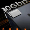 Portables NVMe SSD-Gehäuse auf dunkler Oberfläche mit verschiedenen Speicherkapazitäten.