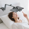 A woman is using an adjustable aluminum tablet stand with a clamp to point at something.