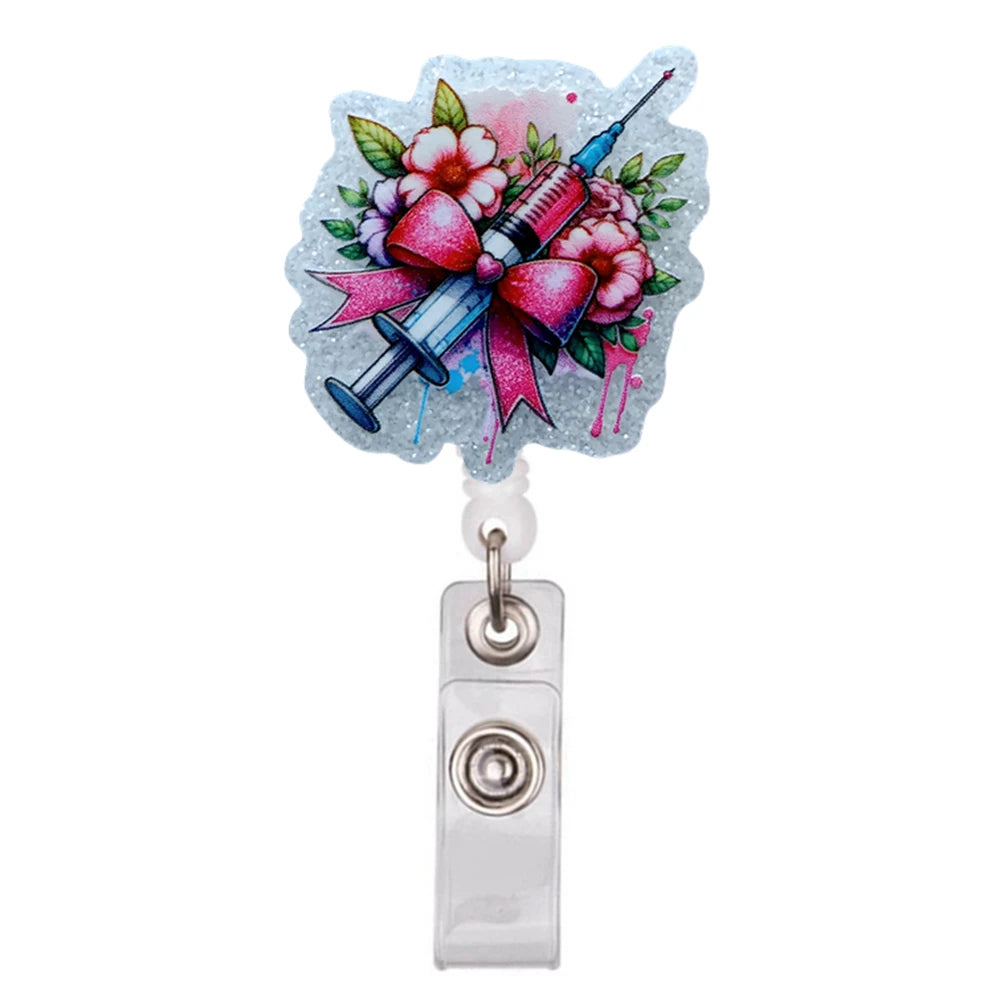 Glitzer-Acryl-Ausweisclip mit stilisierter medizinischer Spritze umgeben von rosa und grünen Blumen