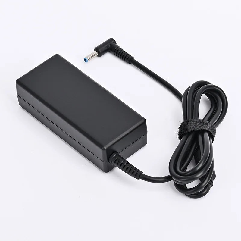 A black universal laptop power adapter with a coiled cable and connector tip.