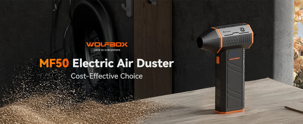 An orange and black Wolfbox MF50 Electric Air Duster is shown on a wooden surface with sawdust scattered around it.