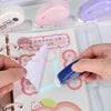 Eine Hand appliziert doppelseitiges Klebeband auf weißes Papier für Scrapbooking.