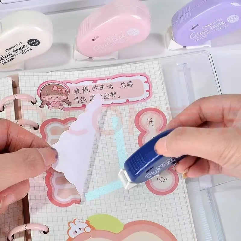 Eine Hand appliziert doppelseitiges Klebeband auf weißes Papier für Scrapbooking.